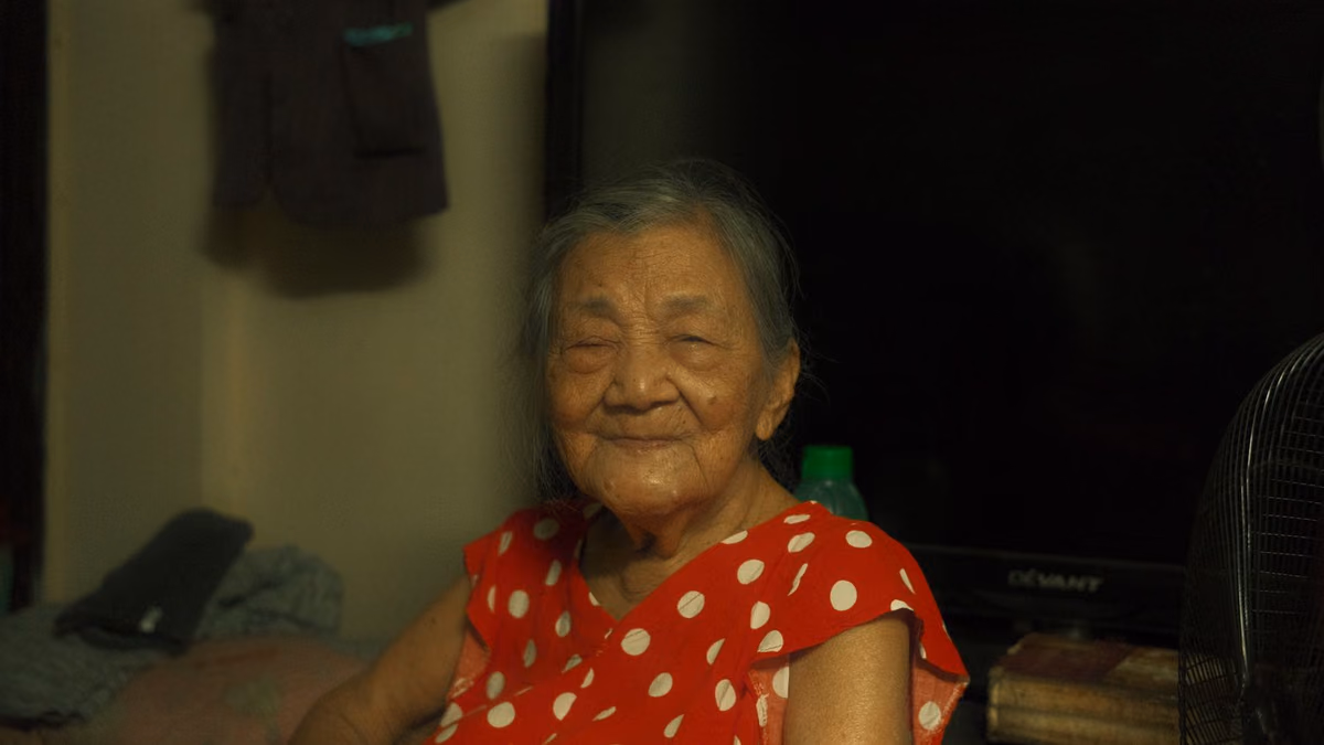 An older woman smiling warmly at home, the age group for whom health rather than age decides whether full-arch implants are suitable.