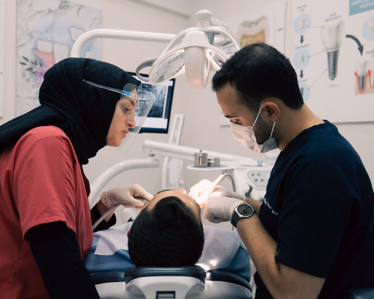 A dental team working together on a patient during an implant procedure, the surgical reality behind full-arch treatment in Malaysia.