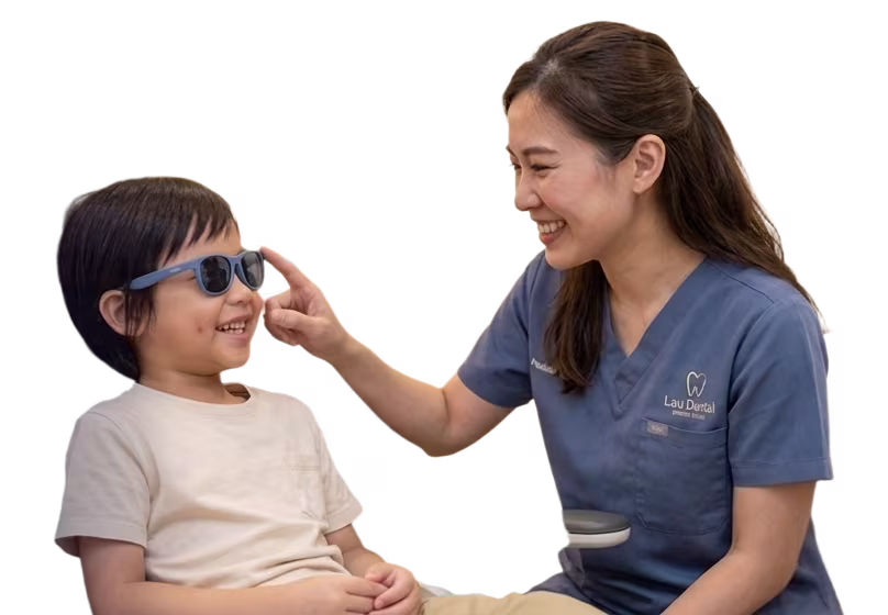 A cheerful young child smiling broadly while sitting comfortably in a modern pediatric dental clinic setting.